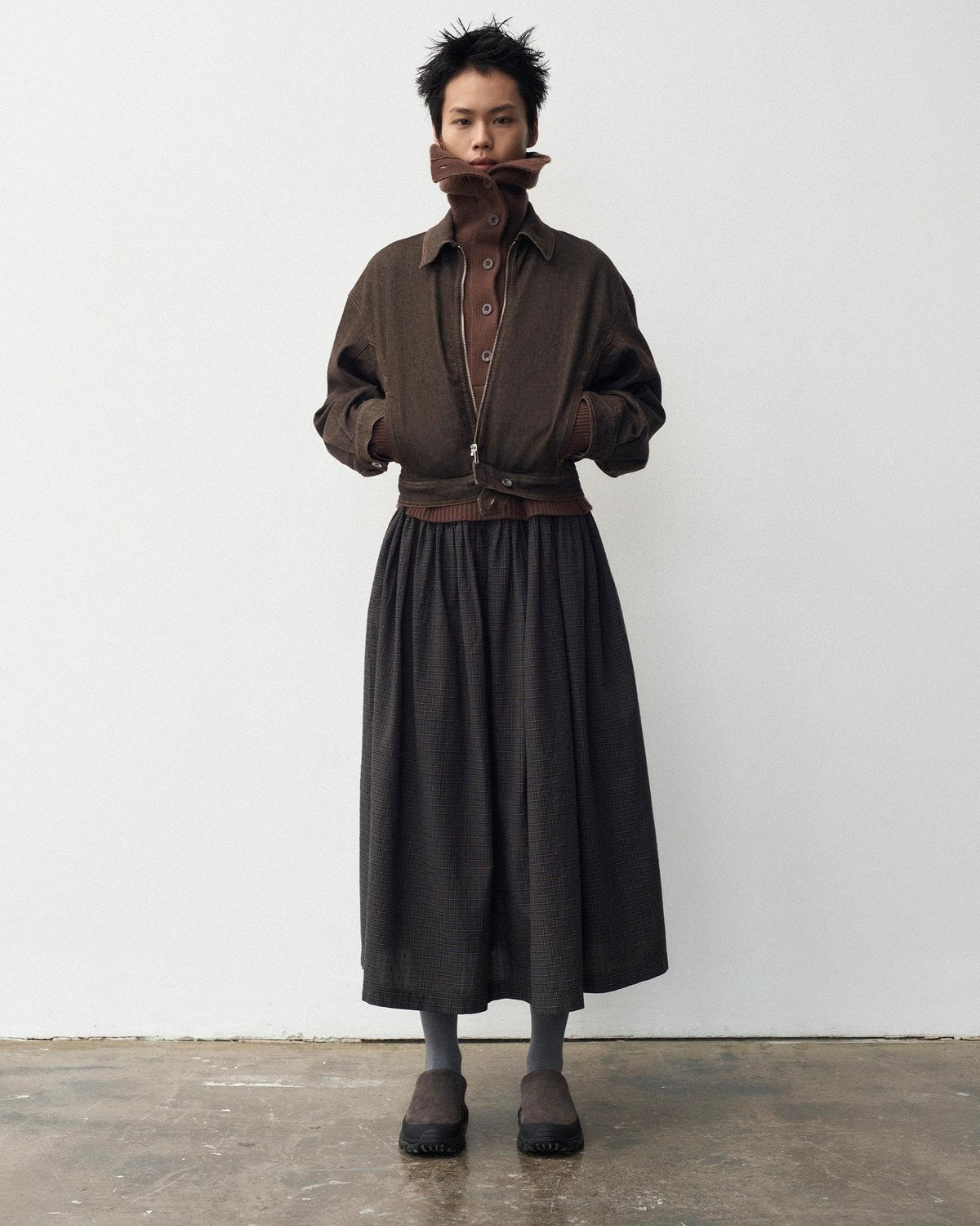 Lookbook YMC AW26, veste marron ceinturée et jupe longue sombre