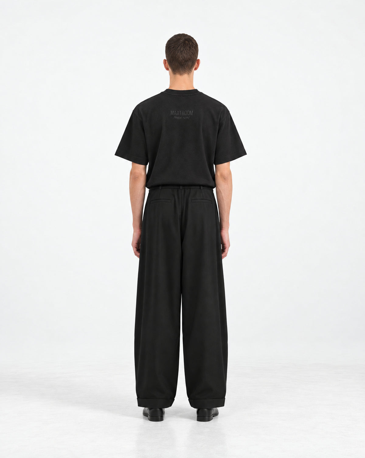 Maatroom T-shirt Izanaghi noir – portée, vue de dos avec logo MAATROOM brodé, avec pantalon noir