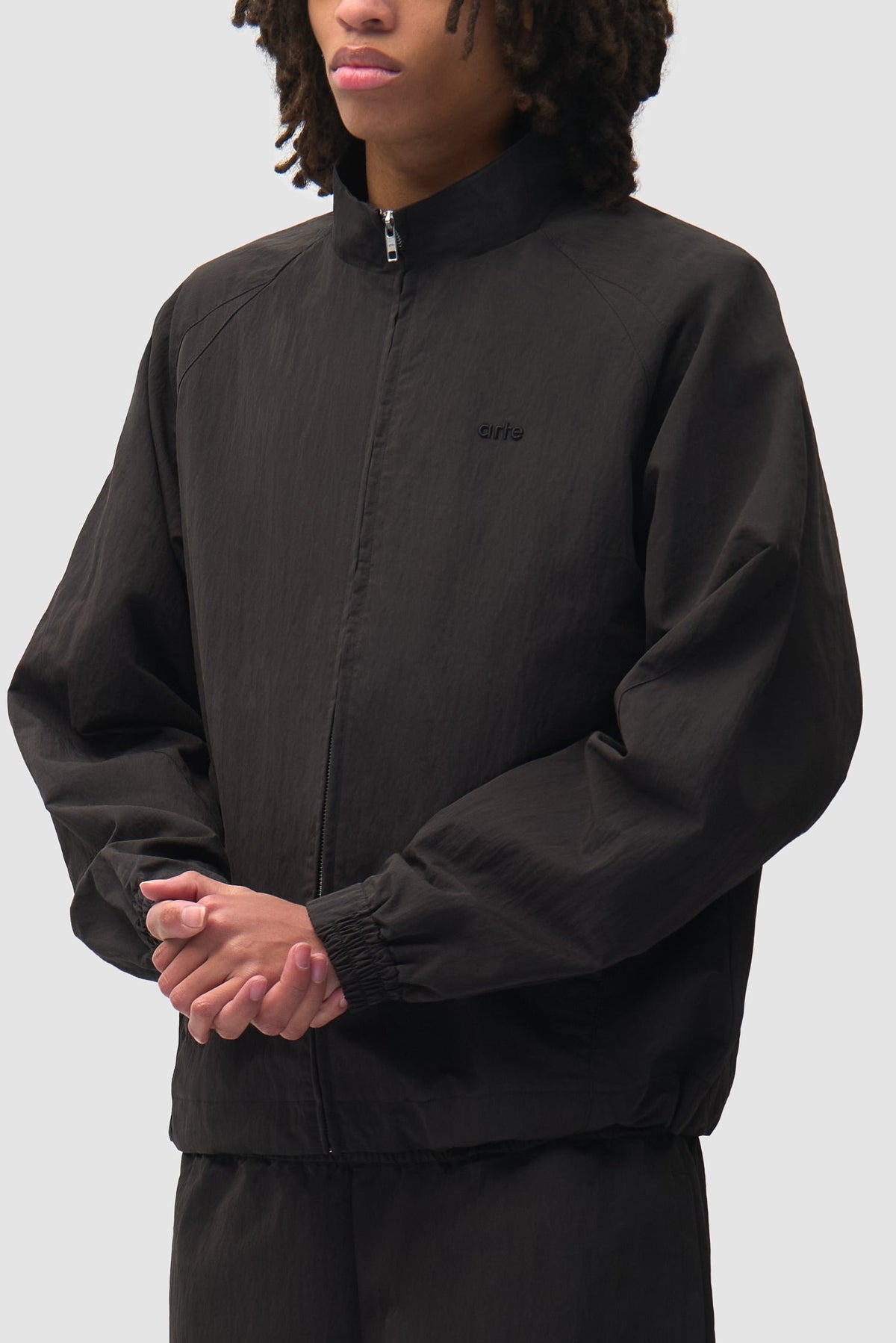 Arte Antwerp Trainingsjacke Uniform schwarz – getragen in Dreiviertelansicht, Nahaufnahme