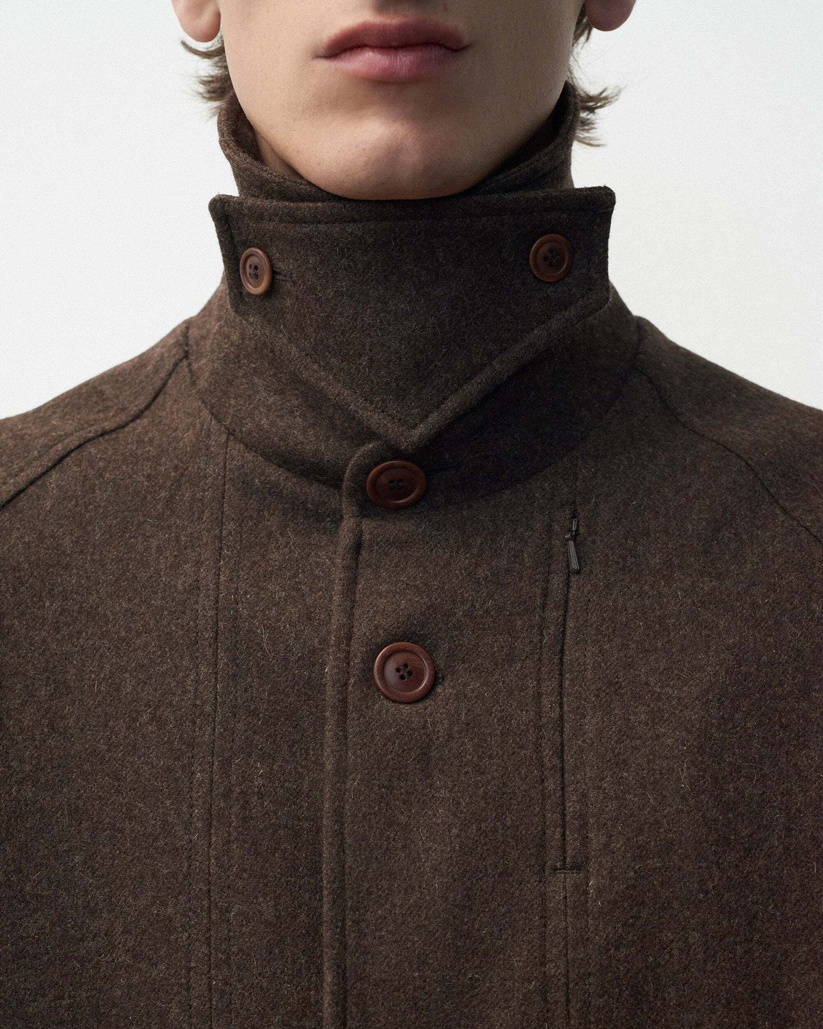 Lookbook YMC AW26, détail d’un col montant boutonné en laine brune