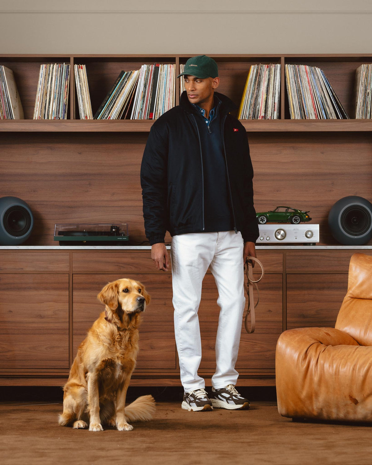 Campagne Mercer Automne-Hiver 2026 — homme et golden retriever devant une bibliothèque de vinyles, Re-Run aux pieds
