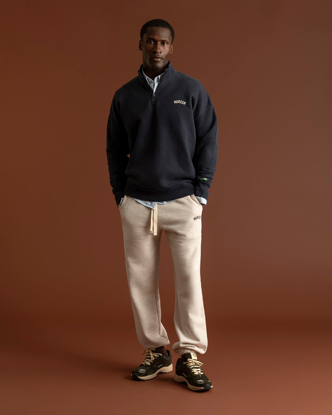 Mercer The Re-Run EVO Nubuck Army Green portée — silhouette en sweat marine et pantalon crème